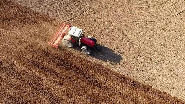 Flight over ploughed field with tractor. 