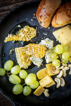 Assortment of cheese with fruits, berries, honey and nuts