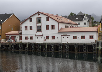 A white house on a pier with some tires to secure that ships moores