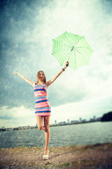 girl under an umbrella walks in the rain