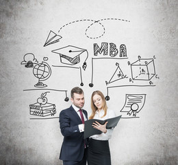 Young prosperous couple are thinking about MBA degree and checking some information in the black...