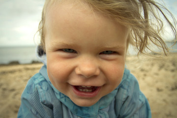 little girl laughing on the beach .