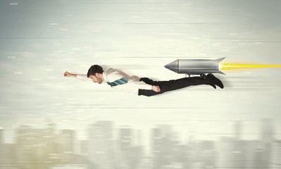 Superhero business man flying with jet pack rocket above the cit
