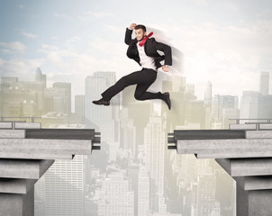 Energetic business man jumping over a bridge with gap