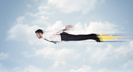 Happy business man flying fast on the sky between clouds
