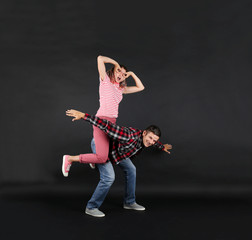 Emotional young couple on black background