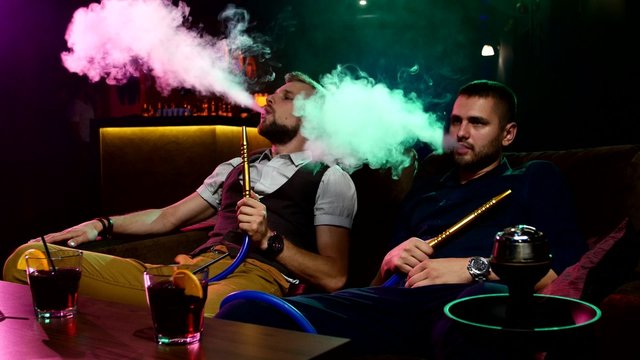 men smoke from shisha pipei n the lounge caffee