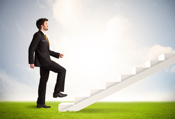 Business person climbing up on white staircase in nature