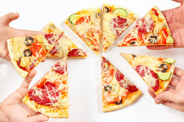 Child and adult hands snapping up pieces of a pizza