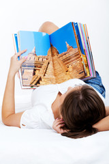 Young woman reading travel magazine