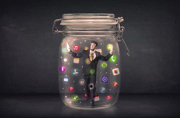 Businessman captured in a glass jar with colourful app icons con