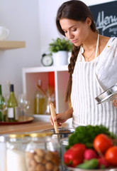 Cooking woman in kitchen with wooden spoon