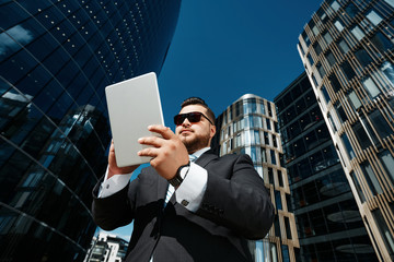 Bottom view portrait of successful business man using touch pad