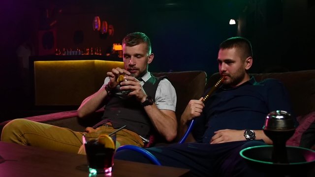 friends smoke from shisha pipei n the lounge caffee. Slow motion