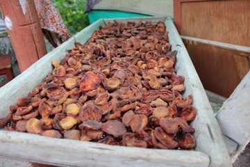 Outdoors drying peaches in a rural environment.