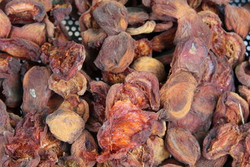 Outdoors drying peaches in a rural environment.