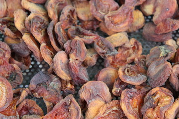 Outdoors drying peaches in a rural environment.