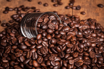 some coffee bean in glass of coffee bean heap on the wood table