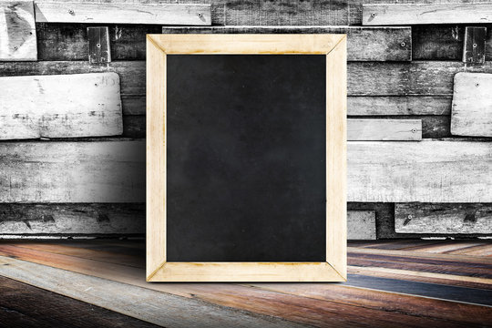 Blank menu blackboard leaning at plank wood wall and diagonal wo