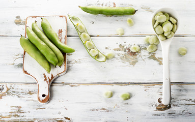 Fresh beans over  white wooden background.