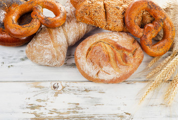 Assortment of  fresh baked bread on a white wooden table.