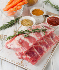 Raw ribs on wooden cutting board.