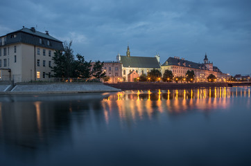 Odra river waterfront in Wroclaw, Poland, with university church and main university building, in early morning, seen from Malt Island (Wyspa Slodowa)