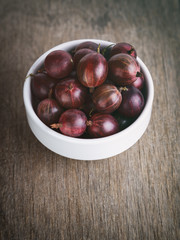 Obraz premium gooseberries in a bowl on a wood background