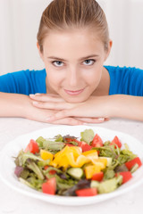 Smiling girl eating salad 