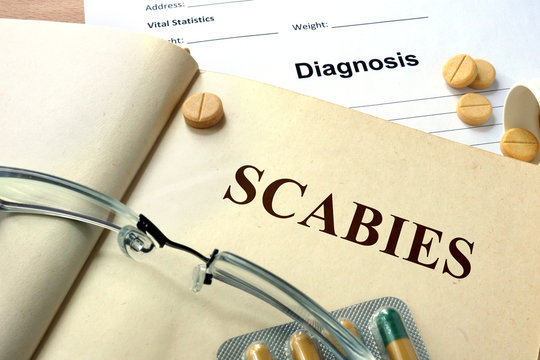 Word Scabies on a paper and pills.