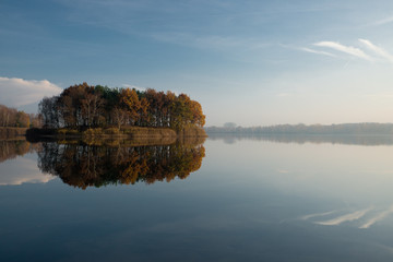 Colorful autumn trees reflected at the pond 
