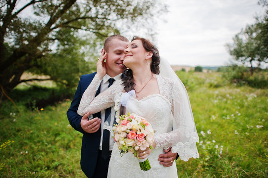 Wedding couple in high grass and near tree