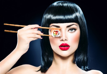 Beautiful woman holding chopsticks with sushi roll