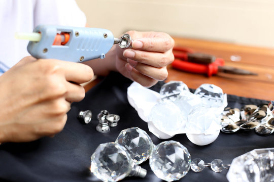 Woman fixing crystal lamps with glue gun