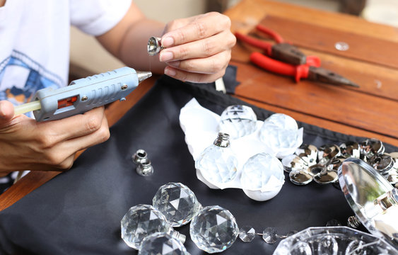 Woman fixing crystal lamps with glue gun