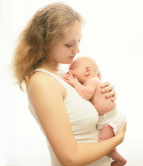 Young loving mother holding on hands sleeping infant