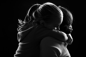 Little girl hugs her mother