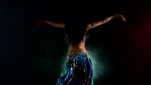 Sexy woman belly dancer arabian in exotic dress dancing, on red