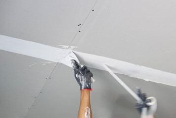 Plasterer spreading plaster to ceiling