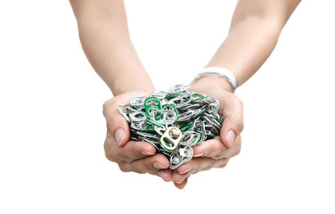 Hand holding aluminium cap can over a pile of cap can