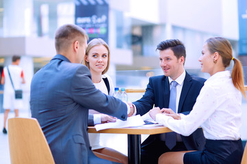 Group of happy young business people in a meeting at office