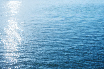 good blue background of water with sun reflections