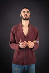 Handsome man doing different expressions in different sets of clothes: prayer