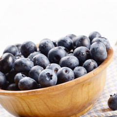 Wooden bowl with organic blueberries