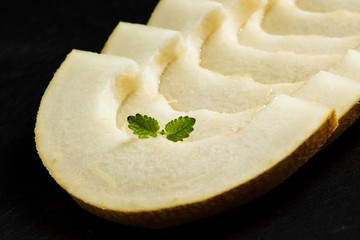 Ripe melon on a dark background, selective focus