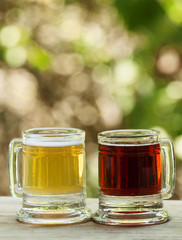 Light and dark beer in an old-fashioned circles on blurred natur