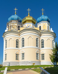 Church with three blue and golden domes against cloudless sky