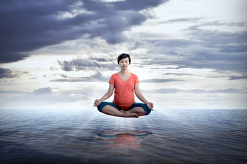 Pregnant mother doing yoga on the sea