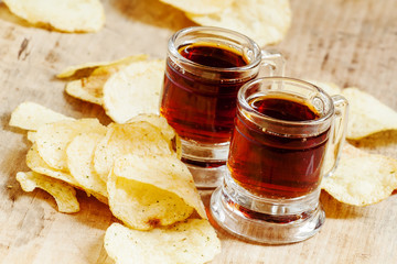 Pair of dark beer and chips, unhealthy eating concept, selective