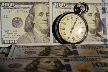 The timer on the background of dollar bills (advantages and disadvantages of credit,  crisis - concept)